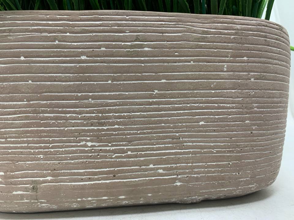 FAUX GRASS IN PLANTER.