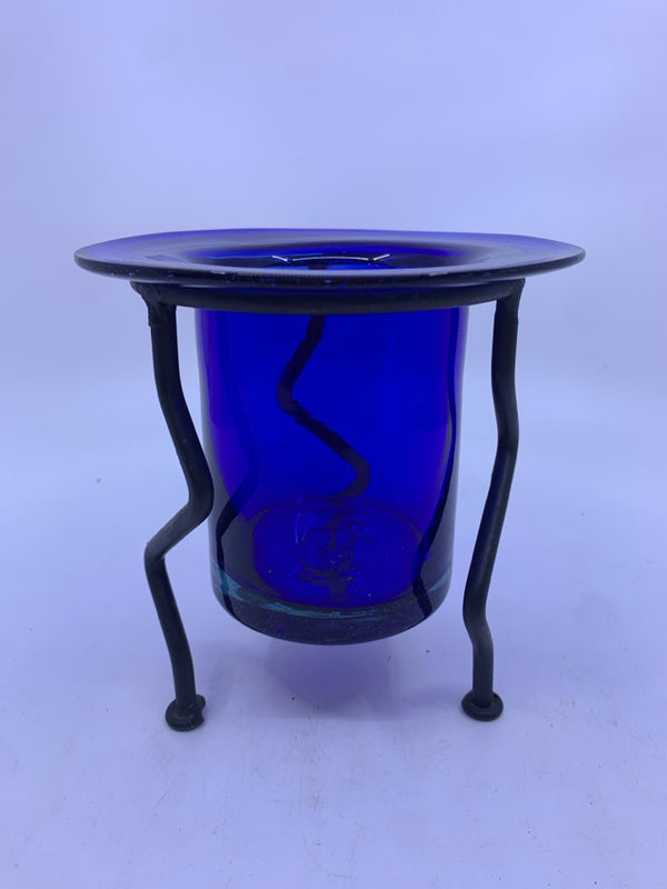 BLUE GLASS CANDLE HOLDER IN BLACK IRON STAND.