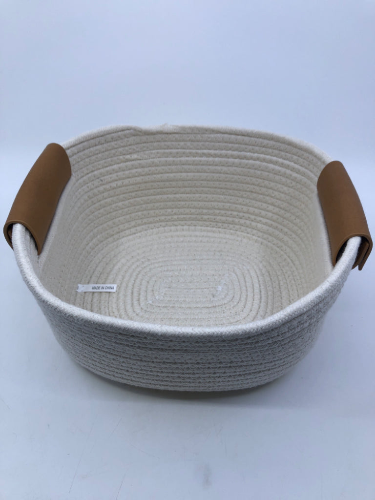 CREAM WOVEN FABRIC BASKET W FAUX LEATHER HANDLES.