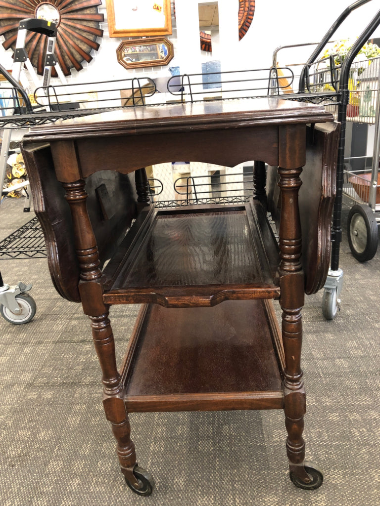 VTG DRK WOOD ROLLING TABLE W/FOLD-UP LEAVES & SLIDE DRAWER.