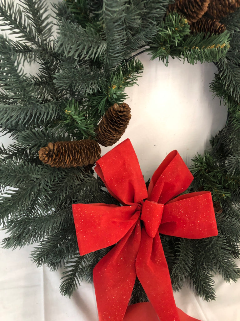 LARGE WREATH W PINE CONES AND RED BOW.