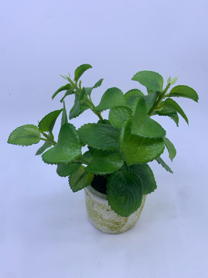FAUX GREENS IN WHITE CEMENT STYLE PLANTER.