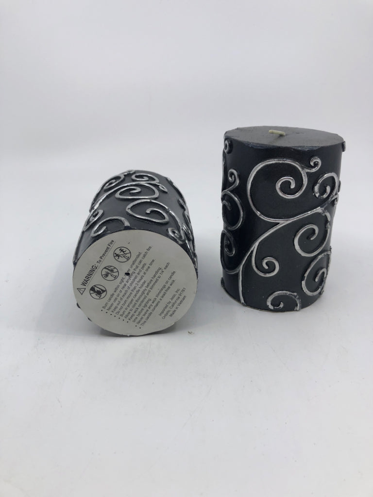 2 BLACK SCROLL PILLAR CANDLES.