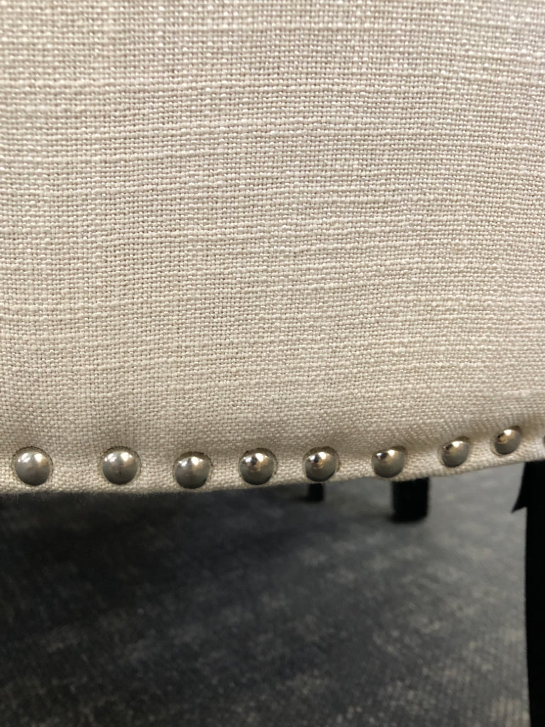 WHITE ACCENT CHAIR STUDDED BOTTOM W/ BLACK LEGS.