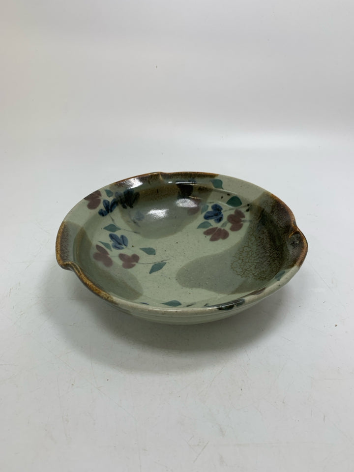 MULTI COLORED POTTERY BOWL W/ RED/BLUE FLOWERS UNEVEN EDGE.