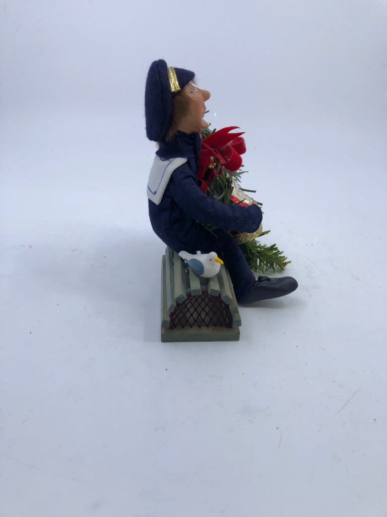 BYERS' CHOICE FISHERMAN SITTING W GARLAND.