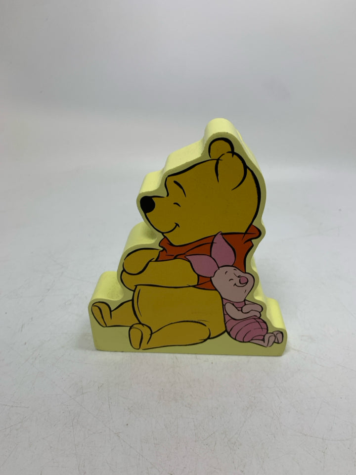 WINNIE THE POOH & PIGLET RESTED AGAINST EACHOTHER.