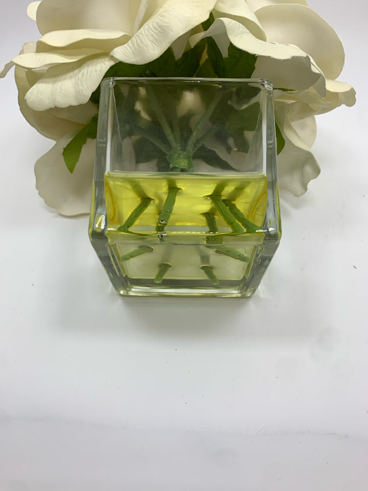 WHITE FAUX ROSES IN SQUARE GLASS VASE.