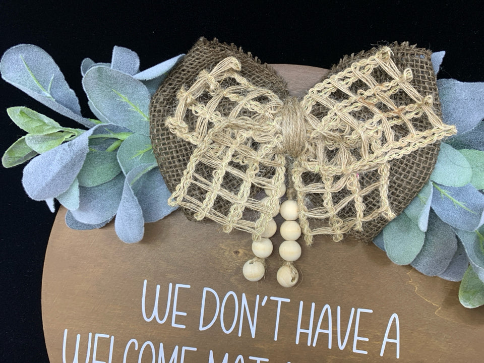 ROUND "WE DON'T HAVE A WELCOME MAT" DOOR HANGING.