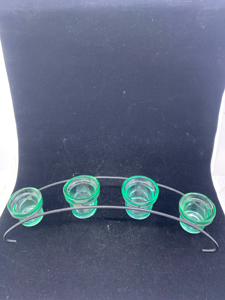 4 GREEN GLASS TEA LIGHT HOLDERS IN BLACK ARCHED STAND.