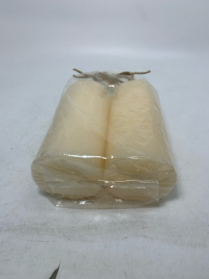 NIP 2 CREAM COLORED PILLAR CANDLES.