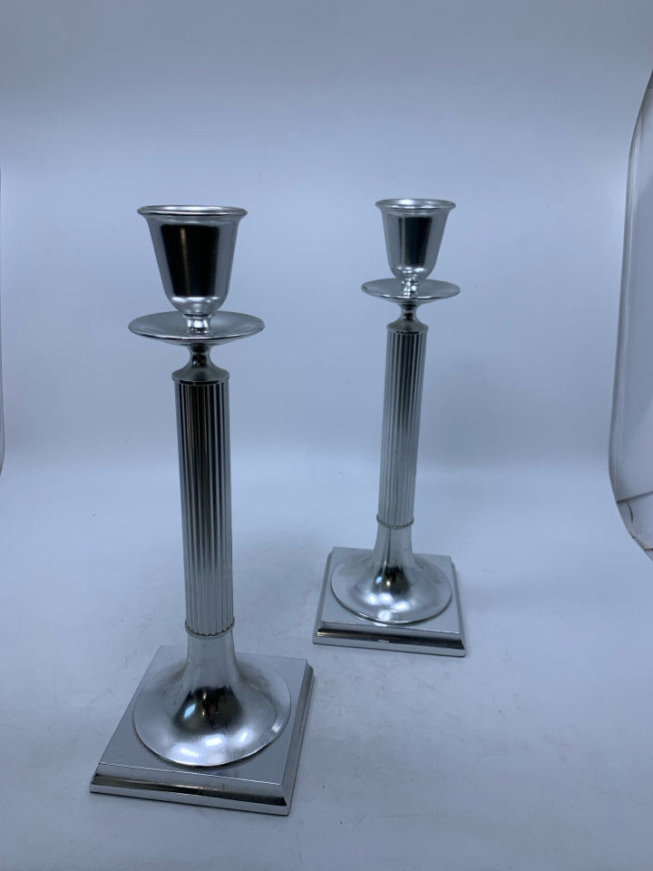 2 TALL SILVER METAL PILLAR CANDLE HOLDERS.