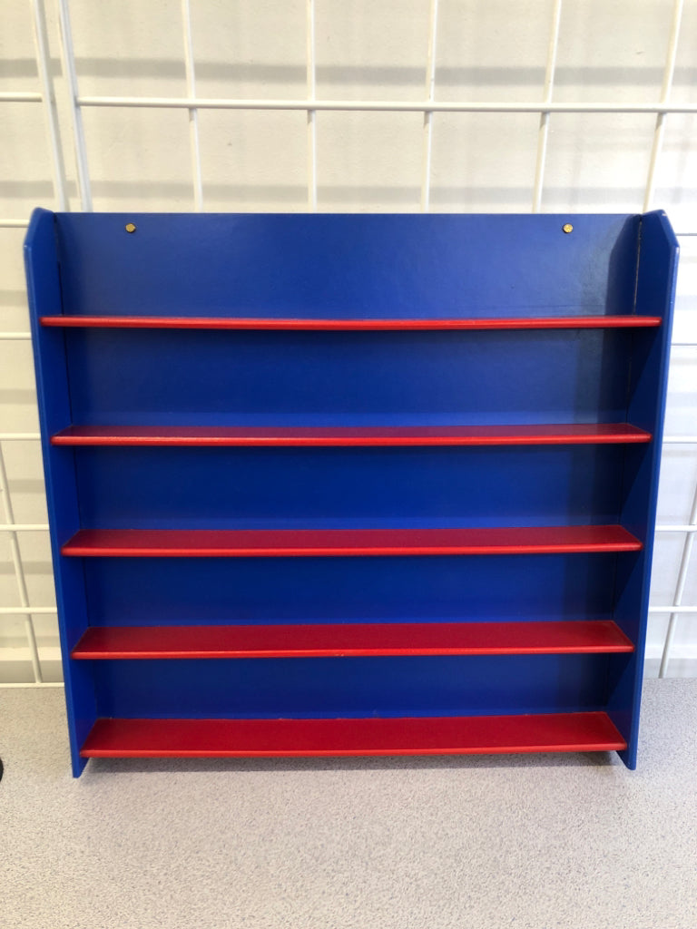 BLUE WALL HANGING W RED SHELVES.