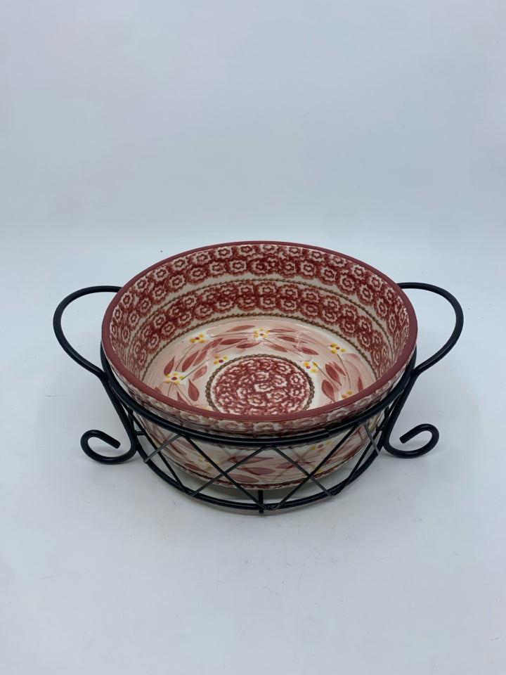 ROUND CASSEROLE DISH IN BLACK METAL STAND.