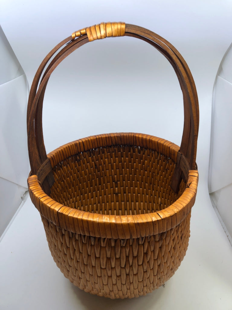 SMALL ROUND ORANGE TIGHT WEAVE BASKET W/ 3 CROSSED HANDLE.