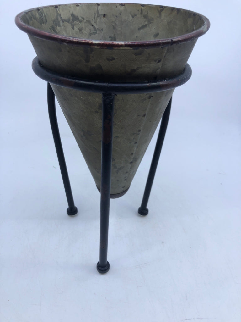 GALVANIZED CONE SHAPED PLANTER IN BLACK FOOTED STAND.