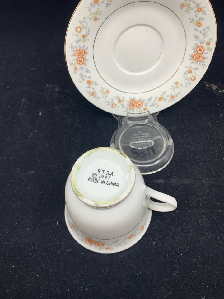 ORANGE AND BLUE FLORAL TEA CUP AND SAUCER.