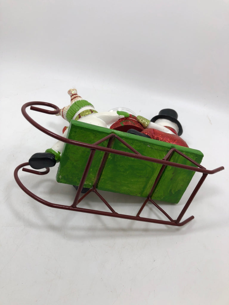 SNOWMEN ON SLEIGH HOLDING VOTIVE HOLDER.