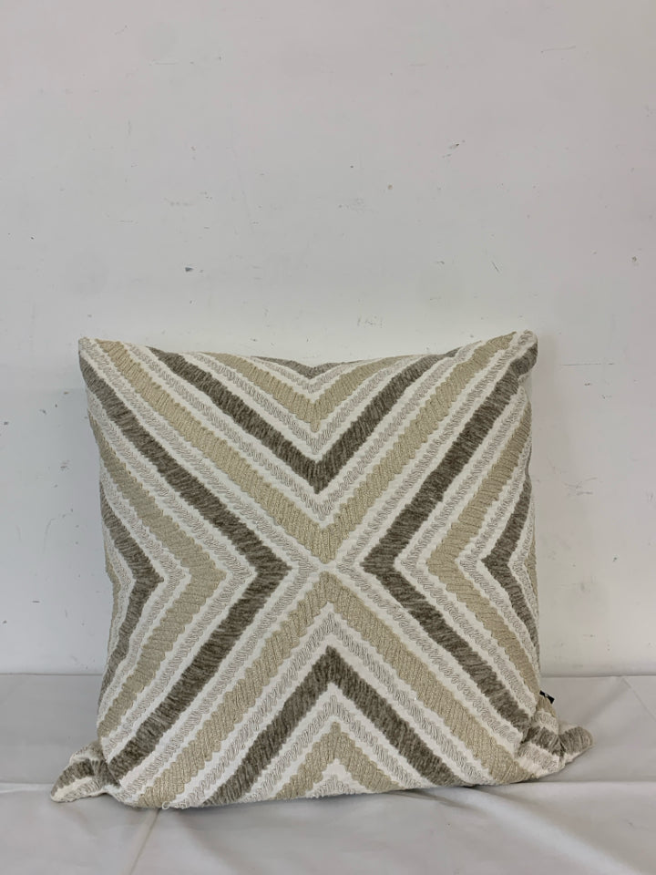 CREAM PILLOW W TAN AND BROWN CHEVRON PATTERN.