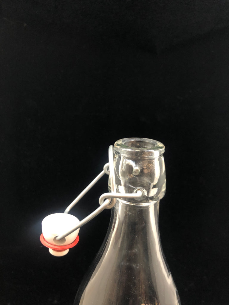 CLEAR GLASS BOTTLE W/FLIP TOP STOPPER.