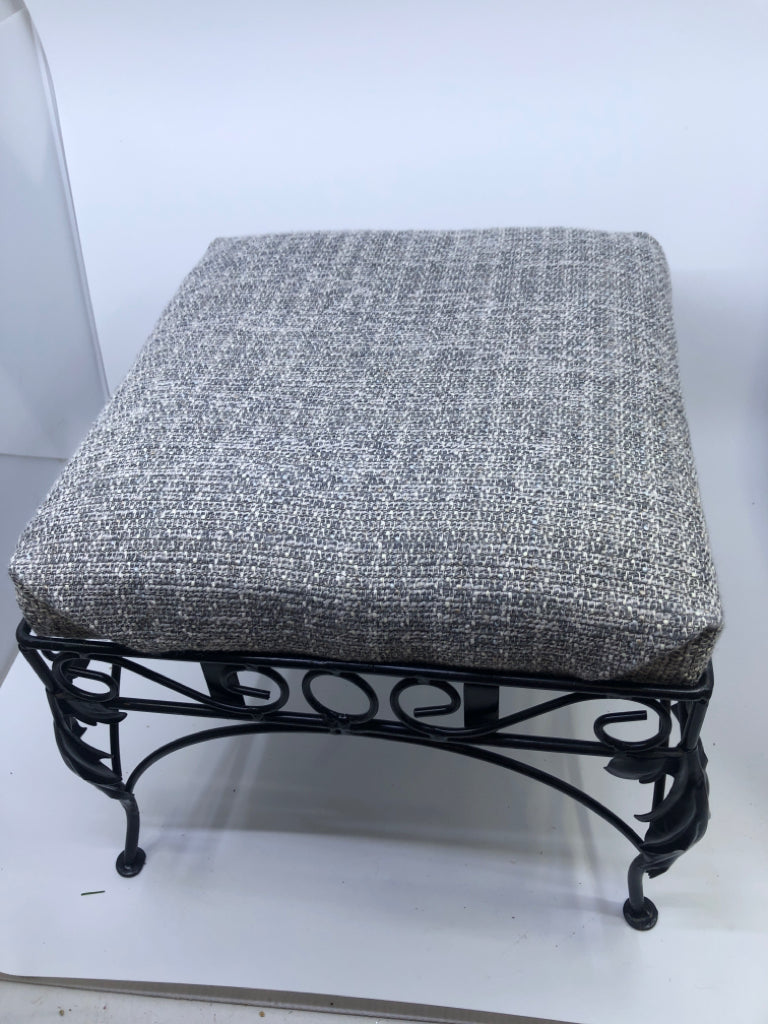 GREY FABRIC FOOTSTOOL W/BLACK IRON SCROLL LEGS.