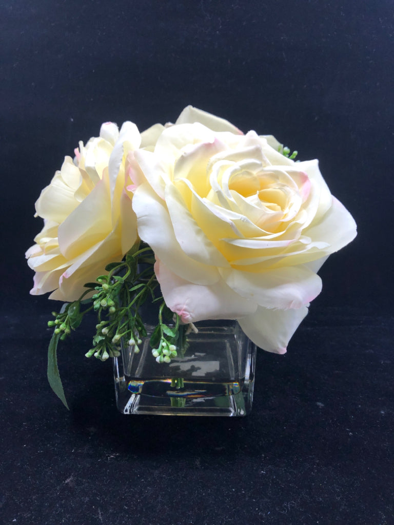 3 LARGE FAUX WHITE ROSES IN CLEAR SQUARE GLASS VASE.