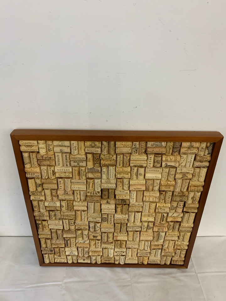 WINE CORKS IN A WOOD FRAME.