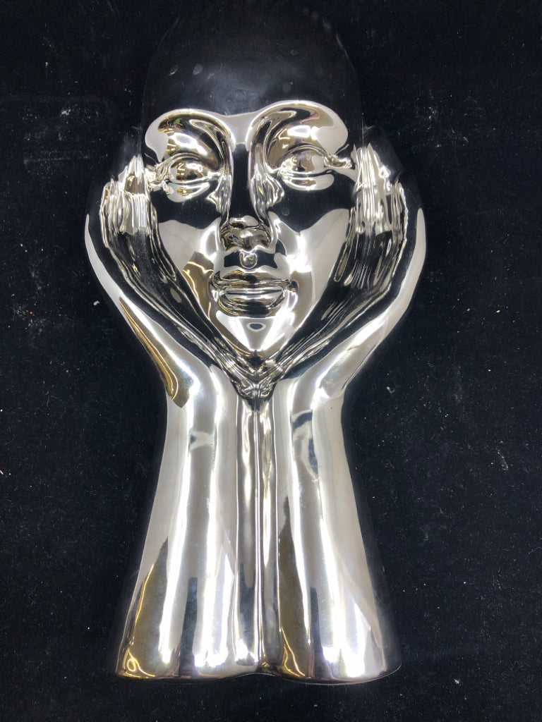 CERAMIC SILVER PERSON HOLDING UP THEIR FACE.