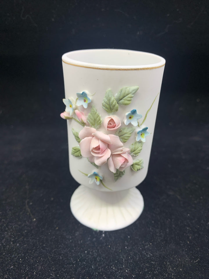 VTG WHITE FOOTED VASE W/ EMBOSSED PINK+BLUE FLOWERS.