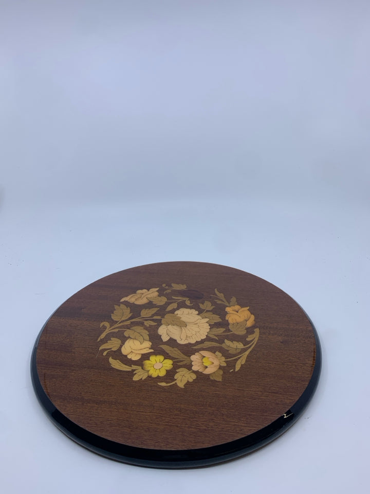 INLAID FACTORY WOOD TRIVET W/ FLORAL DESIGN IN CENTER.