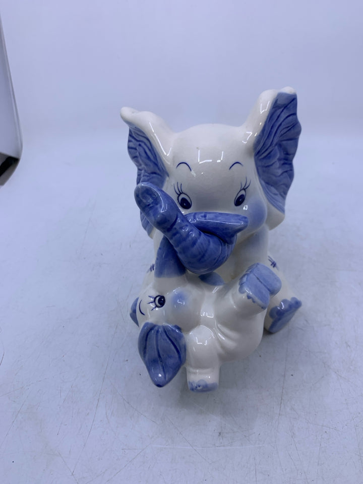 BLUE/WHITE SITTING ELEPHANT W/ BABY HANGING FROM TRUNK COIN BANK.