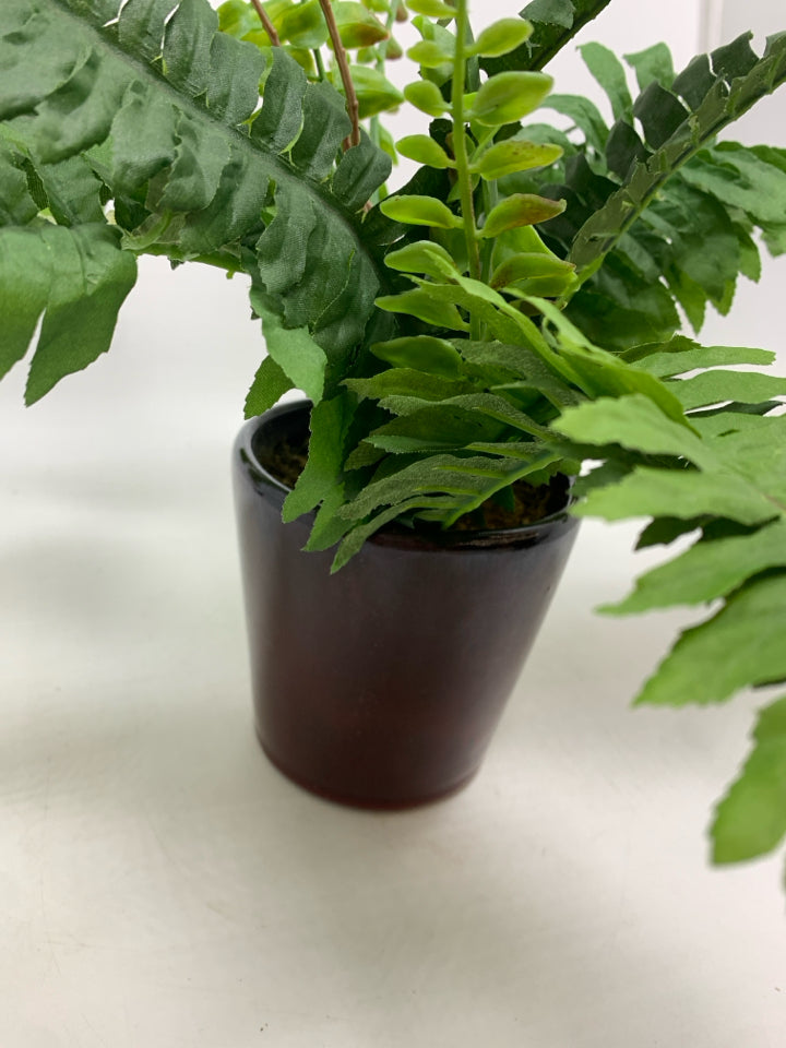 FAUX FERN IN BROWN CERAMIC POT.
