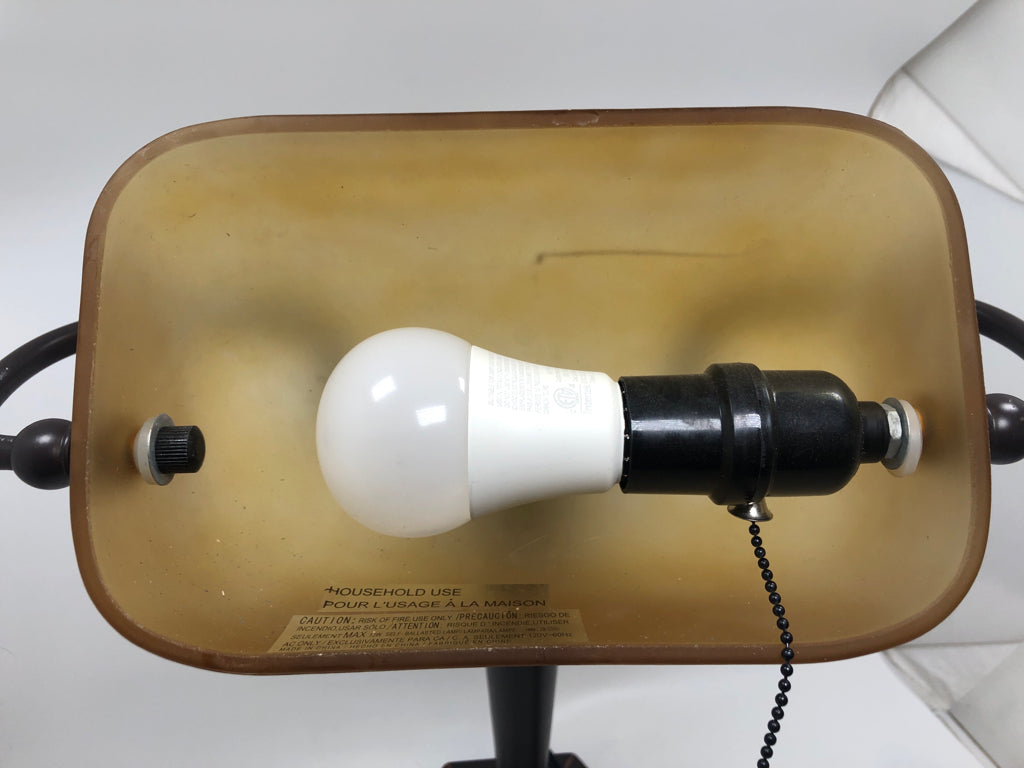 BRONZE BANKERS LAMP W/AMBER GLASS SHADE.
