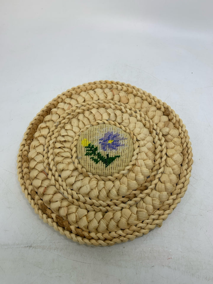 VTG BLONDE WOVEN CIRCLE TRIVET W/ NEEDLE POINT FLORAL CENTER.