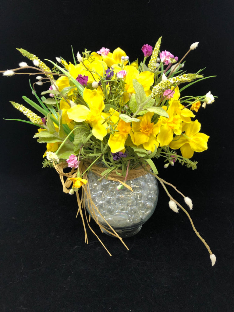 FAUX DAFFODIL BOUQUET IN GLASS VASE W/CLEAR MARBLES.