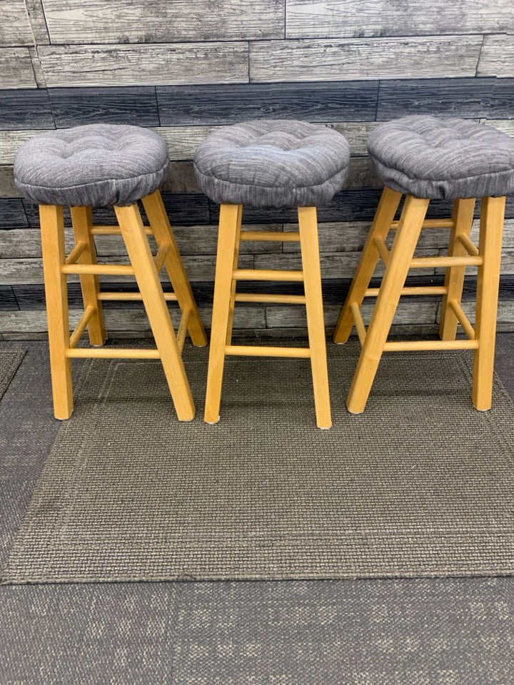 3 LT WOOD STOOLS W/GREY FABRIC SEAT COVERS.