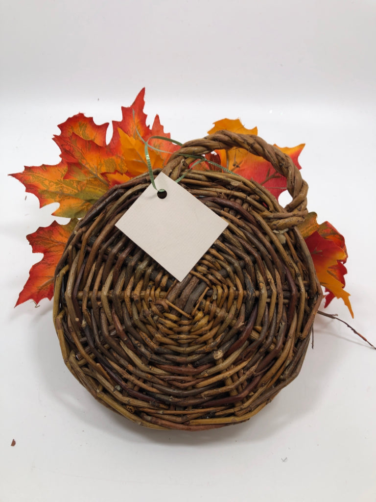 ORANGE LEAVES IN BROWN WICKER HANGING BASKET.