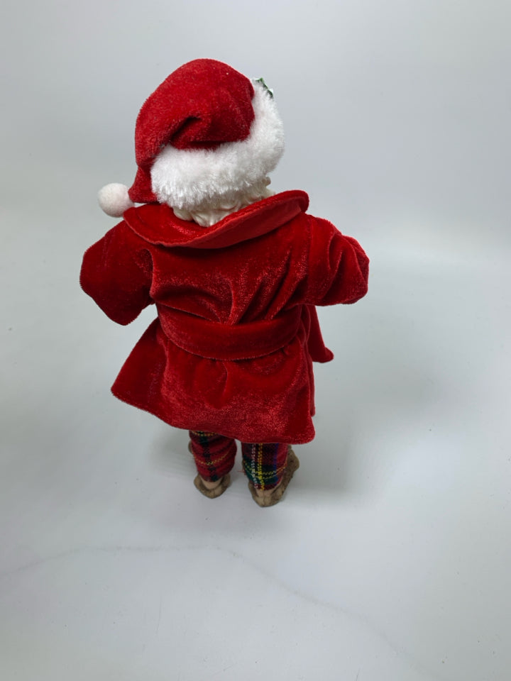 STANDING SANTA IN PJS HOLDING COCOA & COOKIES.