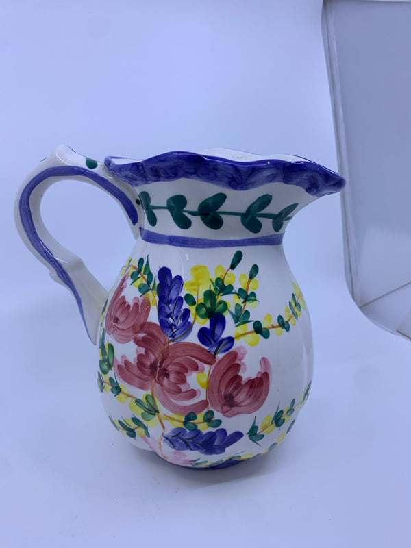 WHITE AND BLUE PITCHER W/ RED AND YELLOW FLOWERS.