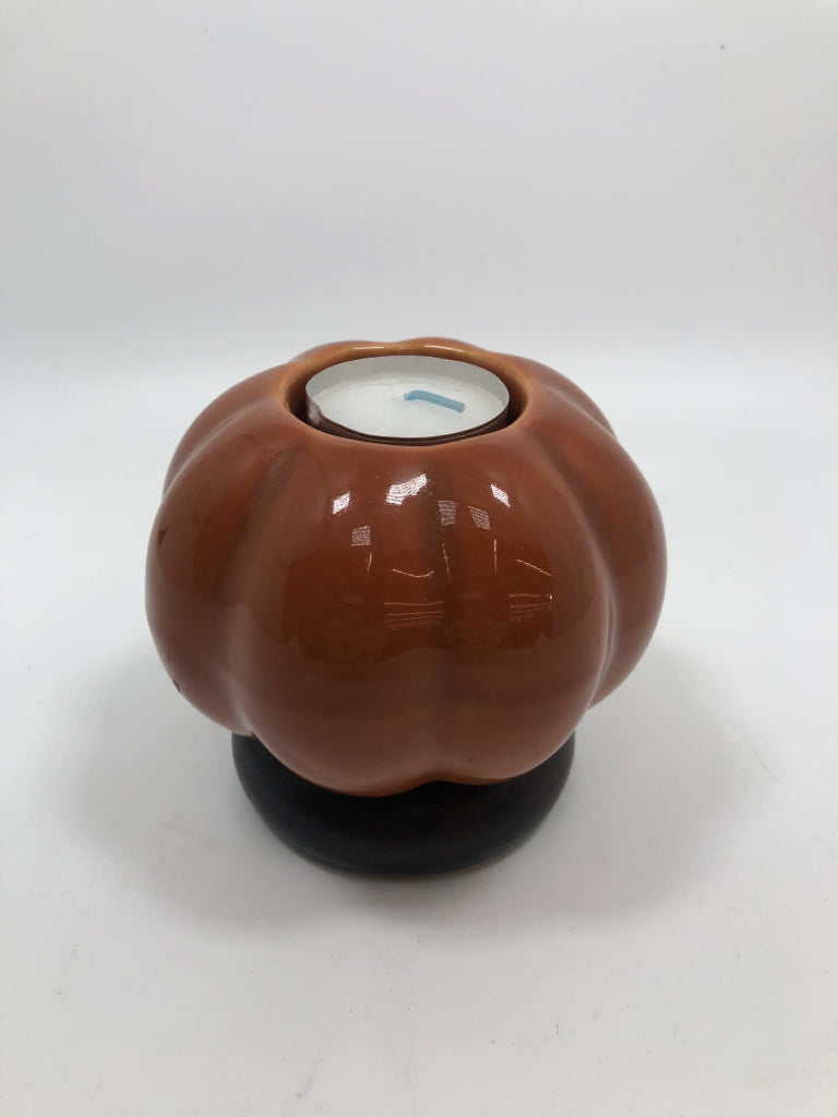 ORANGE CERAMIC PUMPKIN TEALIGHT HOLDER ON WOOD PEDESTAL.