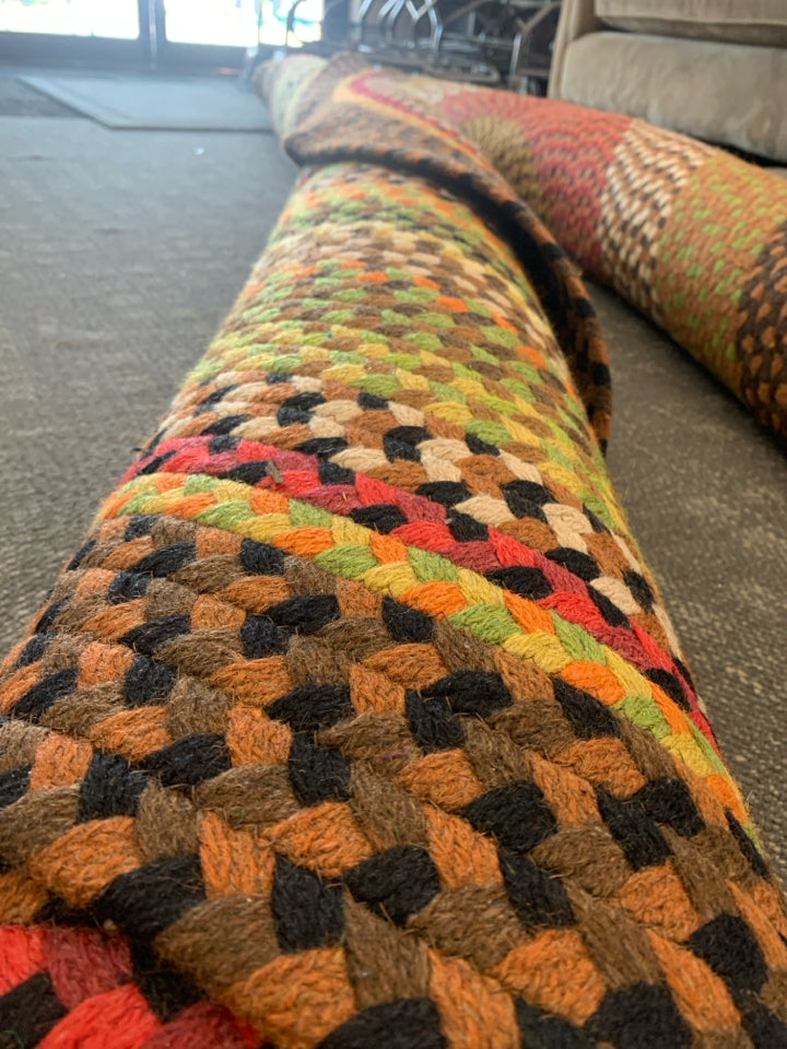 BROWN, RED, GREEN OVAL BRAIDED RUG.