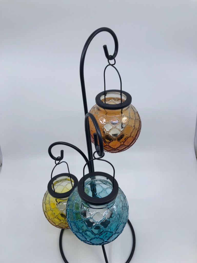 3 COLORED EMBOSSED GLASS TEA LIGHT HOLDER HANGING ON BLACK STAND.