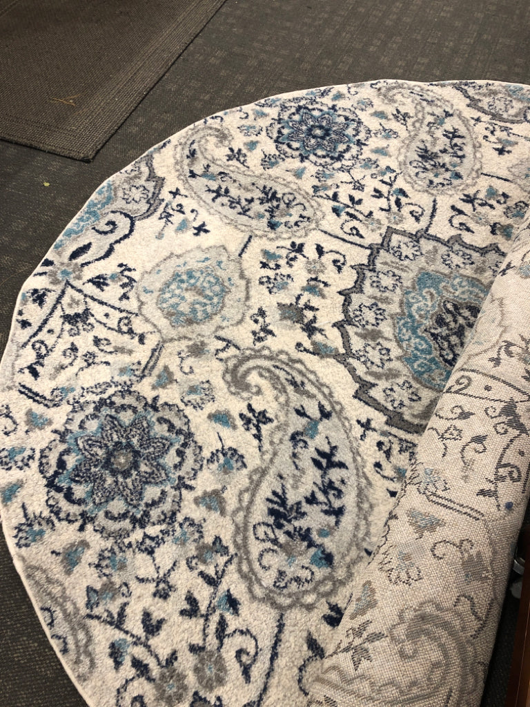 GREY/BLUE ROUND FLORAL RUG.