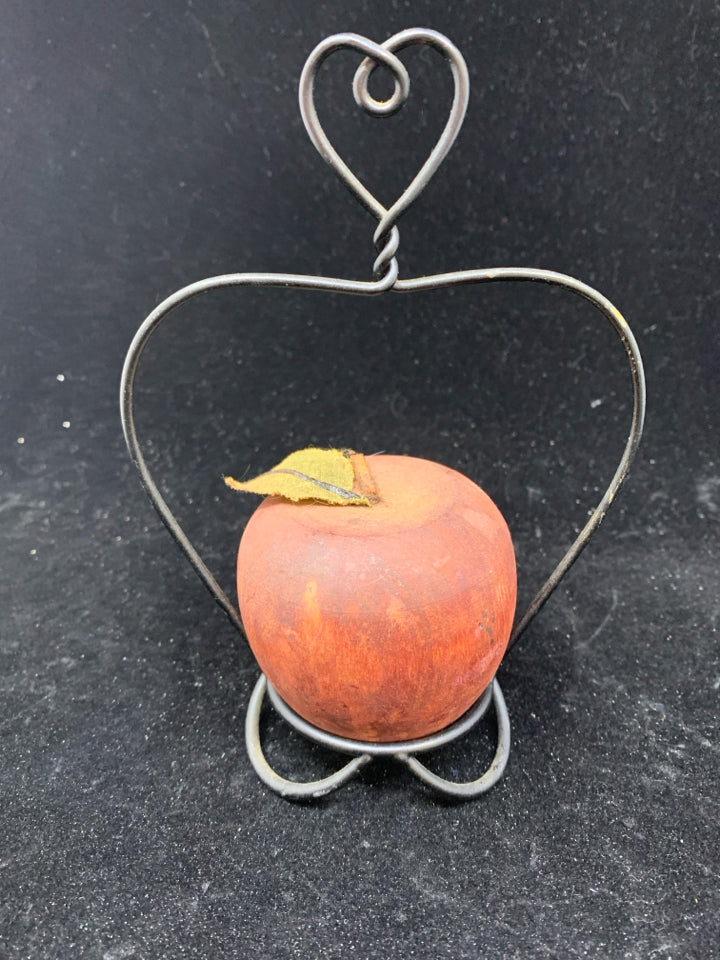 RED PRIMITIVE APPLE ON STAND.