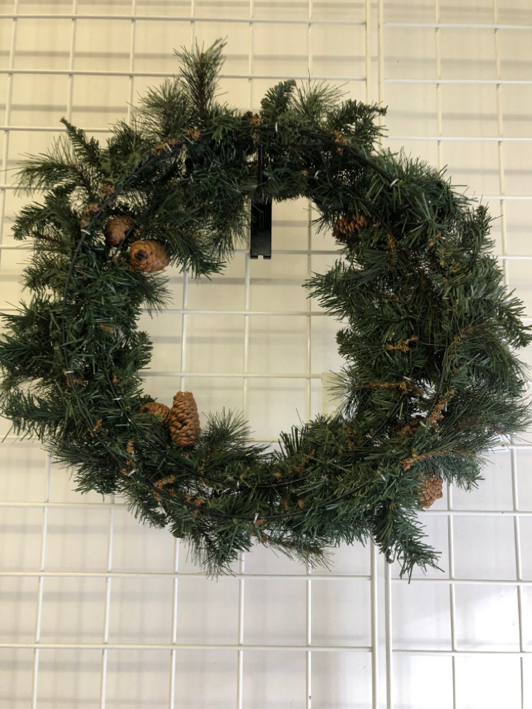 PINE WREATH W/PINECONES AND FAUX SNOW.