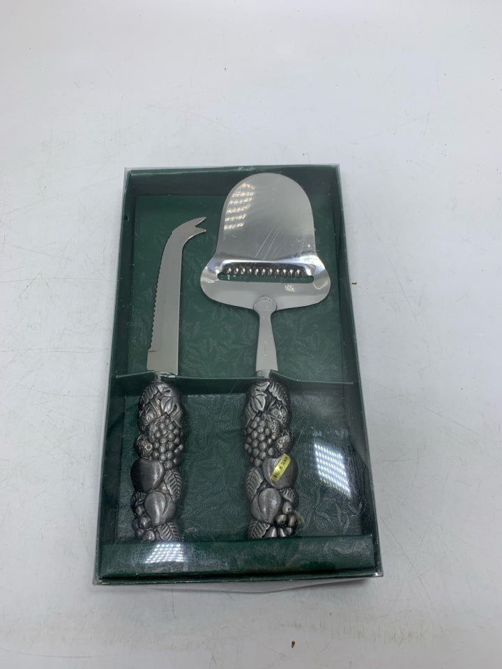 NIP 2 CHEESE KNIFES W/ FRUIT EMBOSSED HANDLES.