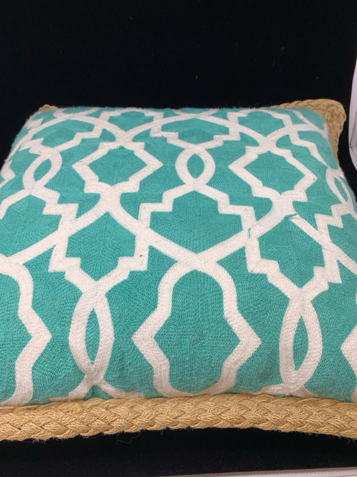 TEAL PILLOW W/WHITE DESIGN & BRAIDED BURLAP BORDER.
