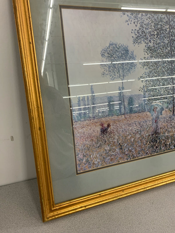 LADY IN FIELD W/ UMBRELLA OIL PAINTING IN GOLD FRAME.