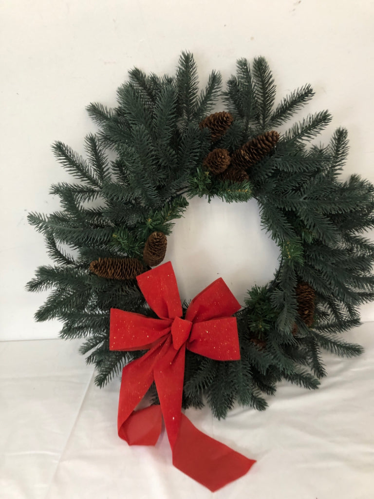 LARGE WREATH W PINE CONES AND RED BOW.