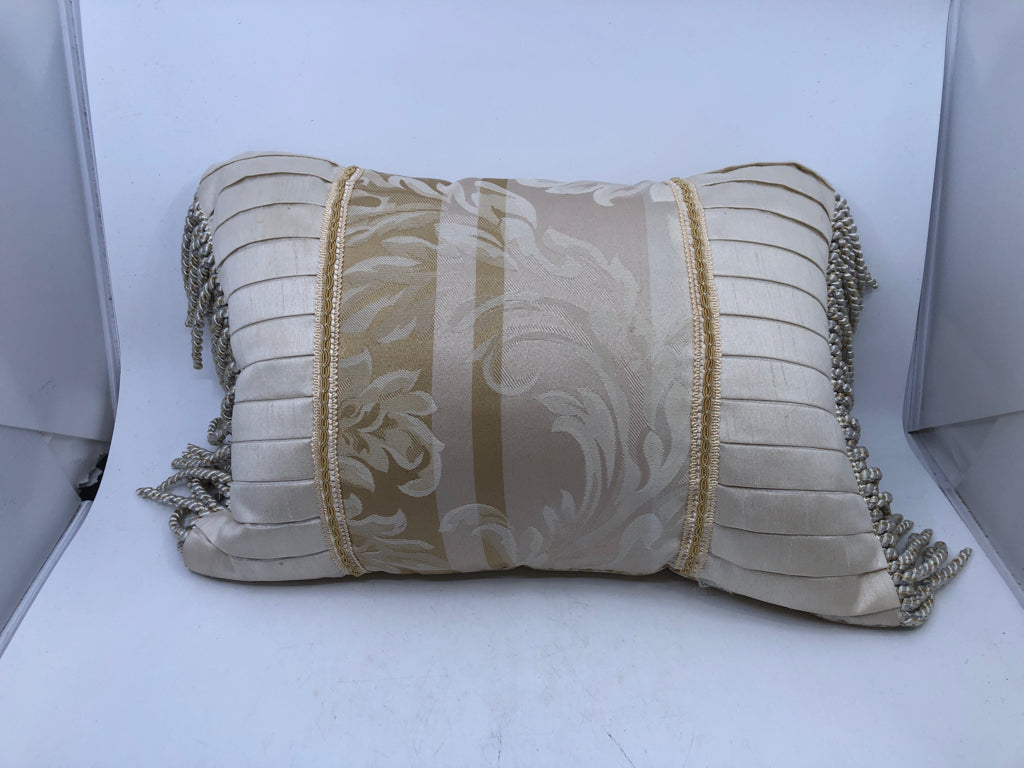 CREAM RECTANGLE AND GOLD PILLOW WITH TASSELS.